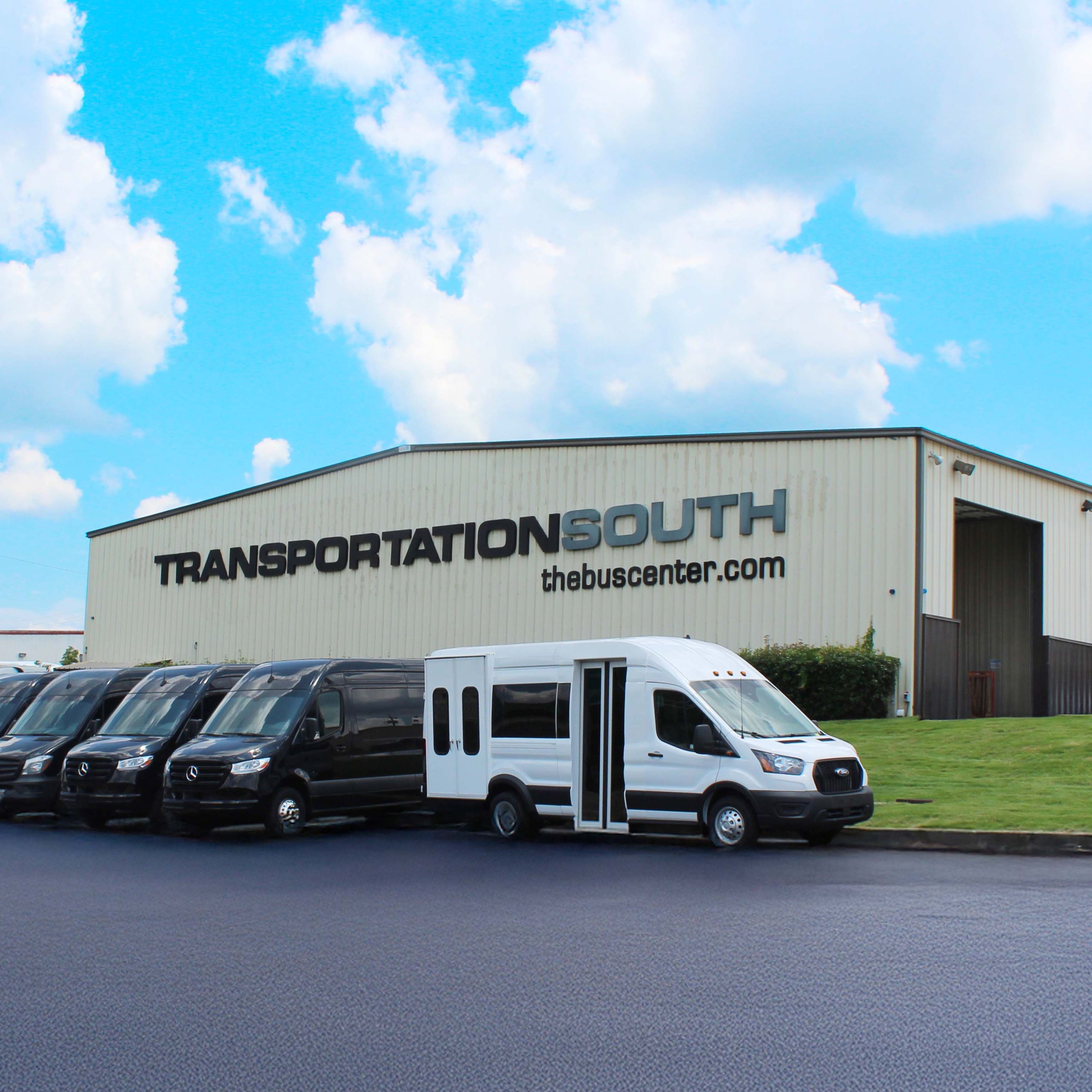 line-up of black and white vans in front of a Bus Center building