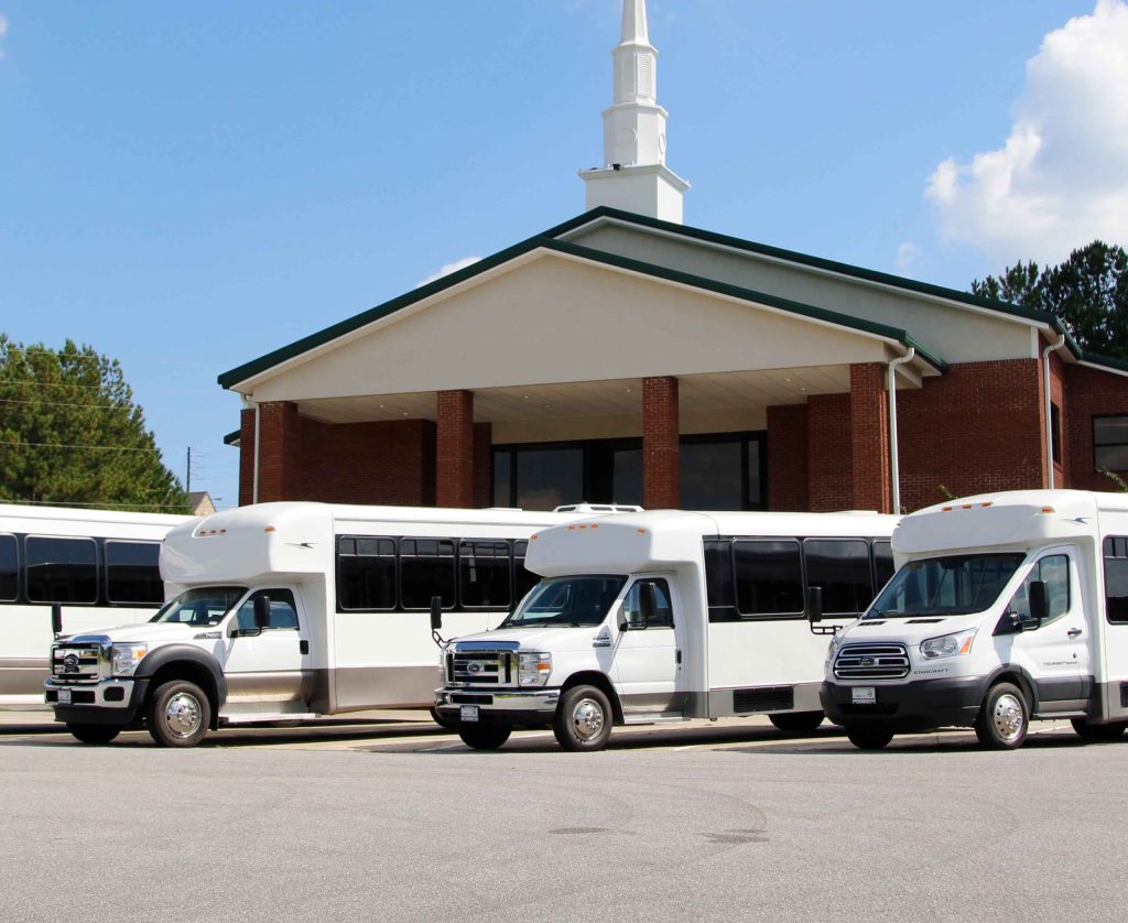buses lined up in front of a church building