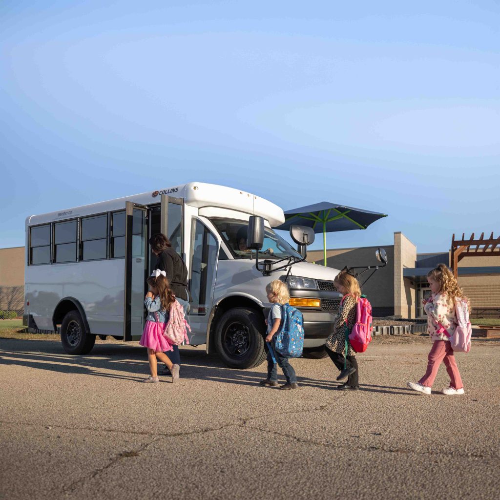 children getting on white activity bus