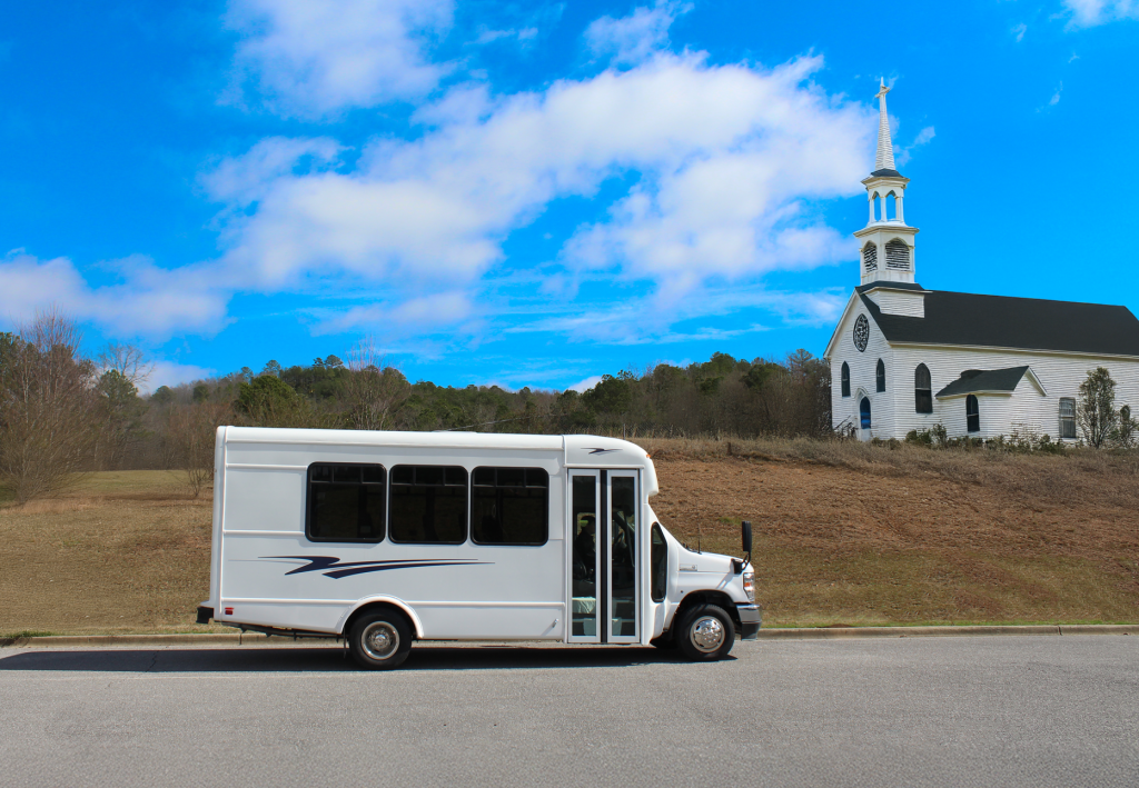 small bus parked in front of a church